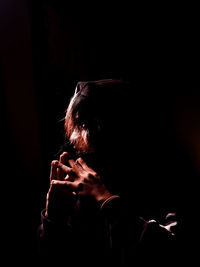 Portrait of man with hand on black background