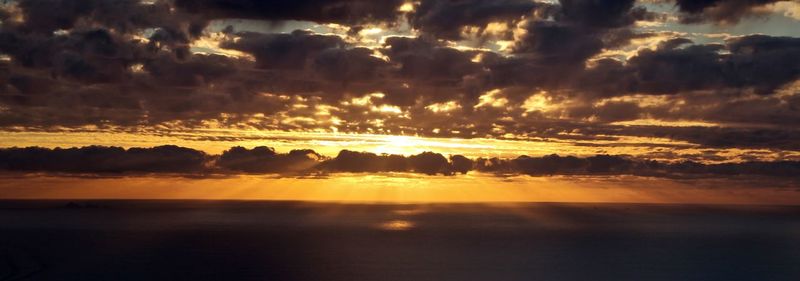 Scenic view of dramatic sky over sea during sunset