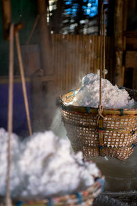 Close-up of ice cream hanging in basket at market stall