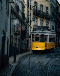 The famous yellow tram going through the streets of lisbon, portugal.