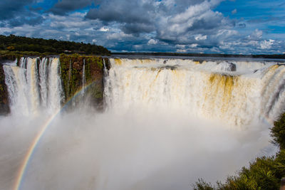 Scenic view of waterfall against sky