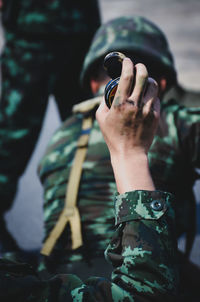 Cropped hand of army soldier holding equipment