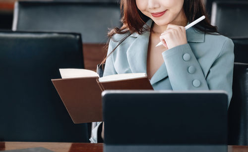 Midsection of woman using laptop on table