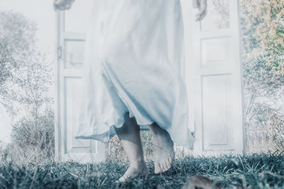 Low section of woman standing on field