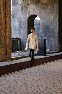 Full length portrait of man standing against wall