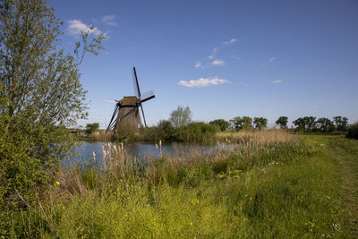 Traditional windmill on field against sky