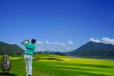 Golfer action to win after long putting golf ball in to the hole