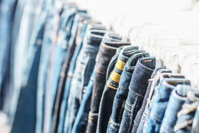 Blue jeans hanging on coathangers at store