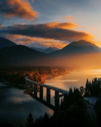 Bridge over river against sky during sunset