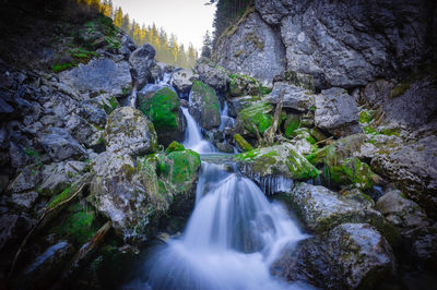 Low angle view of waterfall amidst rocks