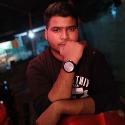 Portrait of young man sitting at night