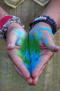 Midsection of girl holding powder paint during holi