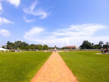 Footpath in park against sky