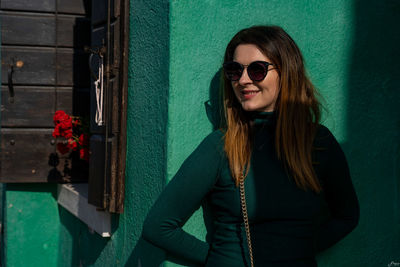 Smiling woman against blue wall