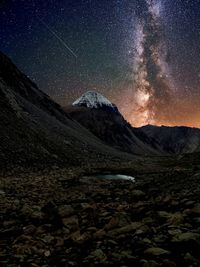 Scenic view of snowcapped mountains against sky at night