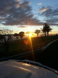 Empty road against cloudy sky at sunset