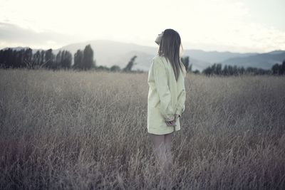 Woman standing on field against sky