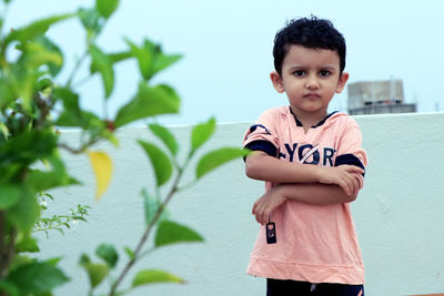 Portrait of boy standing against wall