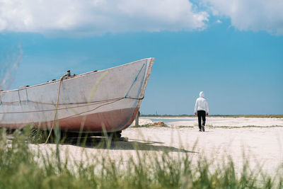 Rear view of man on boat against sky