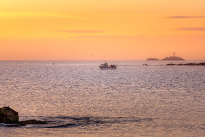 Scenic view of sea against orange sky