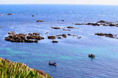 High angle view of rocks in sea against sky