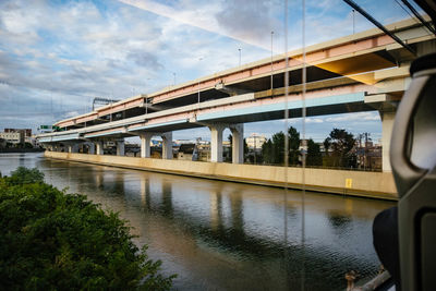 Train on bridge over river against sky