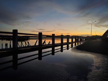 Pier over sea against sky during sunset