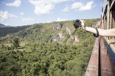 Hand holding a camera over iconic gokteik viaduct, myanmar