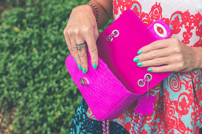 Midsection of woman holding pink hands