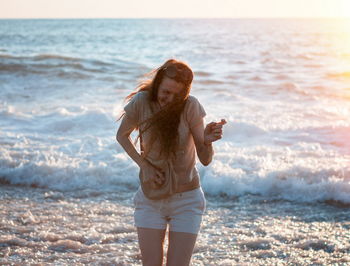 Brunette woman at the sea on sunset