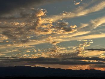 Scenic view of silhouette mountains against sky at sunset