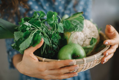 Midsection of woman holding food in basket