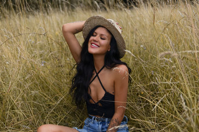 Portrait of young woman sitting on field