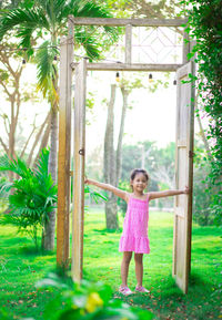 Full length of a girl standing against plants