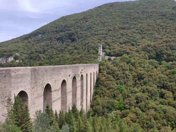 Arch bridge on mountain against sky