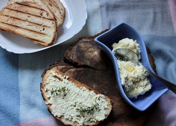 Sandwiches from a loaf and with cheese paste on a wooden stand and in a white plate