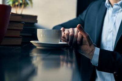 Man holding coffee cup on table