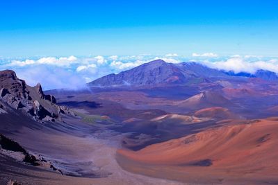 Scenic view of landscape and mountains against blue sky