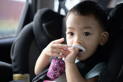 Portrait of cute baby girl in car