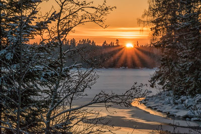 Scenic view of frozen lake against sky during sunset