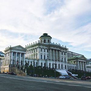 Buildings in city against cloudy sky