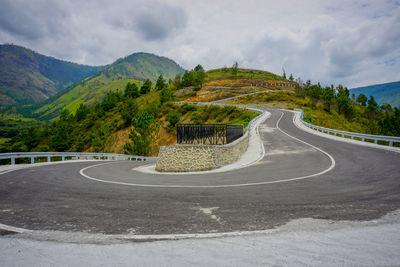 Road leading towards mountains against sky