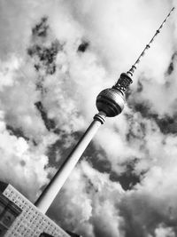 Low angle view of communications tower against sky in city