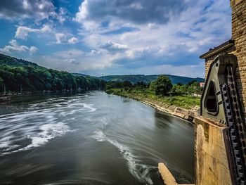 Scenic view of river amidst trees against sky