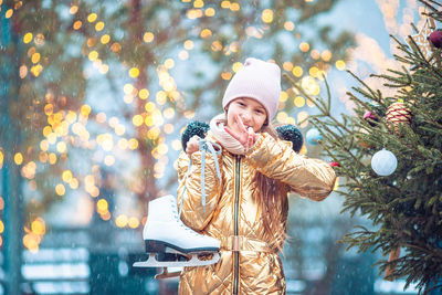 Portrait of woman standing by tree