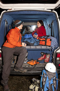 Couple enjoying a hot drink in the back of their camper van