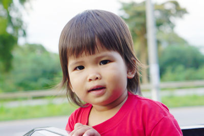 Portrait of cute girl peeking from car roof