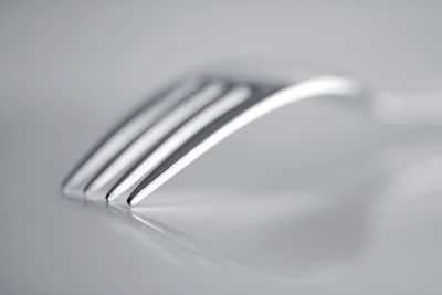 Close-up of spoon on table against white background