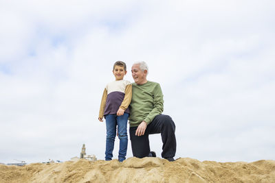 Little boy and his grandfather spending time on the beach