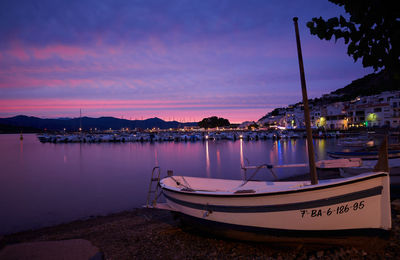 Sailboats moored in marina at sunset